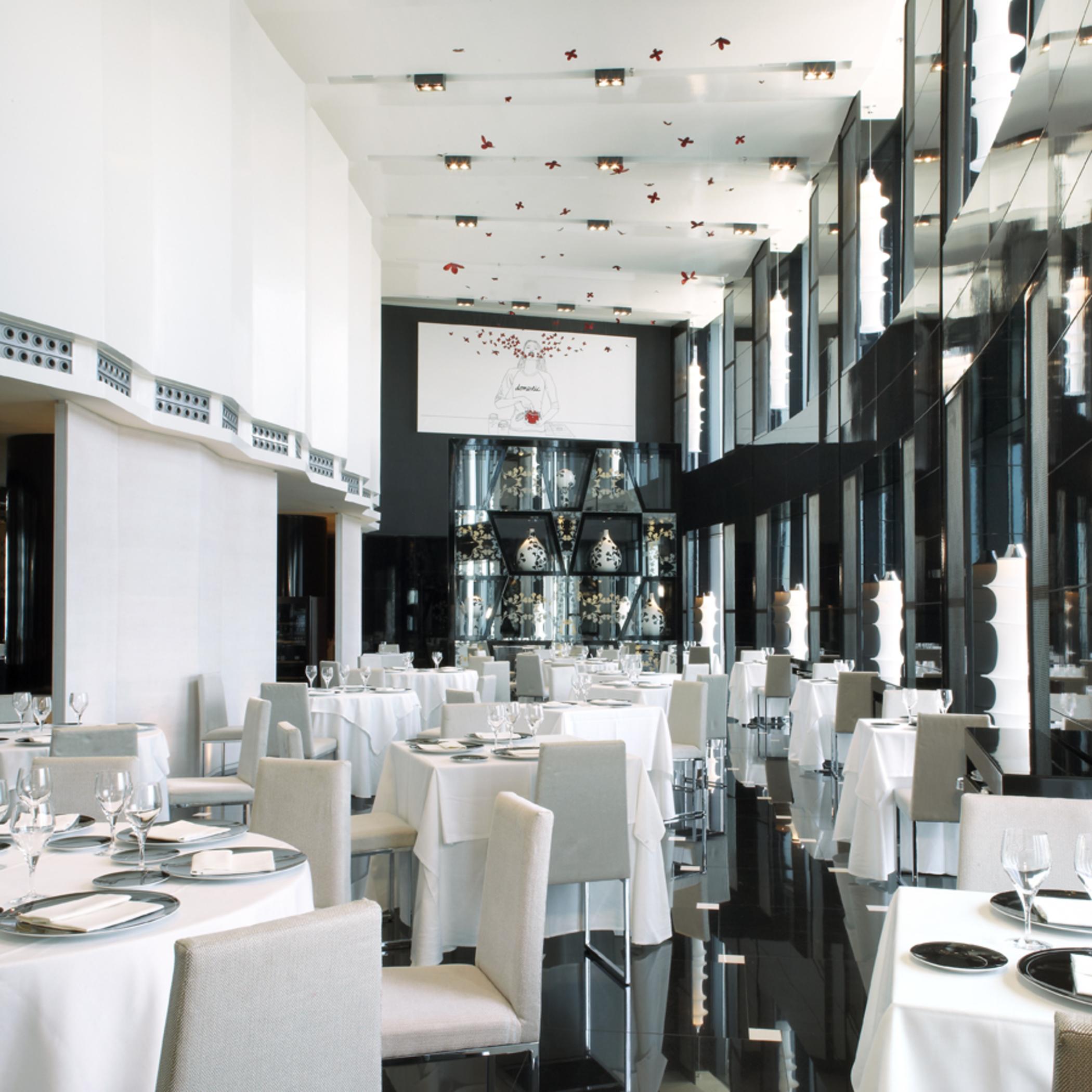 Hotel Eurostars Madrid Tower Esterno foto The photo shows a modern and elegant restaurant interior. The space features tables covered with white tablecloths, arranged neatly with plates and glassware. The decor includes large glass windows that allow natural light to fill the room, and the w