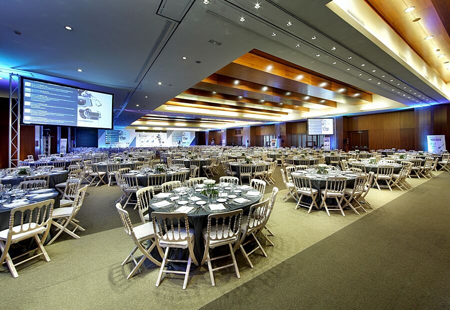 Hotel Eurostars Madrid Tower Esterno foto The photo shows a spacious banquet hall or conference room set up for an event. There are several round tables arranged across the floor, each with elegant table settings, including plates, cutlery, and glasses. The decor features neutral tones, and 