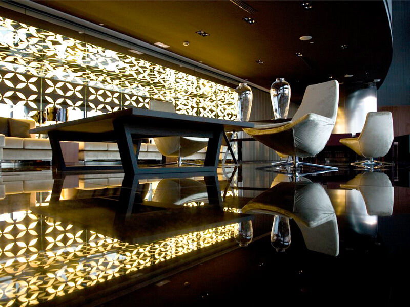 Hotel Eurostars Madrid Tower Esterno foto The photo depicts a modern and stylish interior space, likely a lounge or a bar. Key elements include:

- A sleek, dark floor that reflects the surroundings, enhancing the space's elegance.
- A prominent wall decorated with a unique, intricate patter