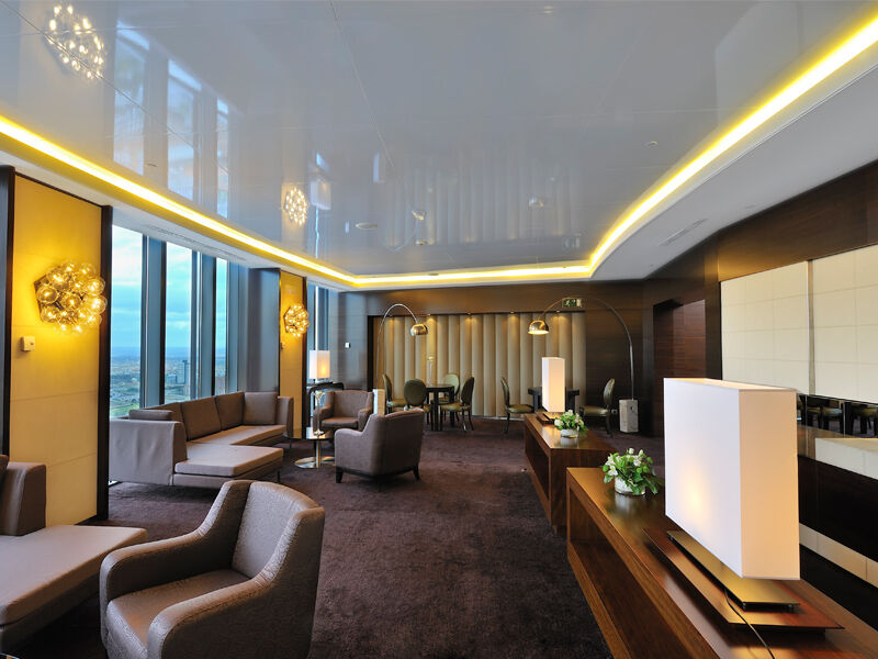 Hotel Eurostars Madrid Tower Esterno foto The photo shows a modern, elegantly designed lounge or reception area. It features large windows that provide a panoramic view, allowing natural light to fill the space. The interior is furnished with contemporary couches and armchairs in neutral ton